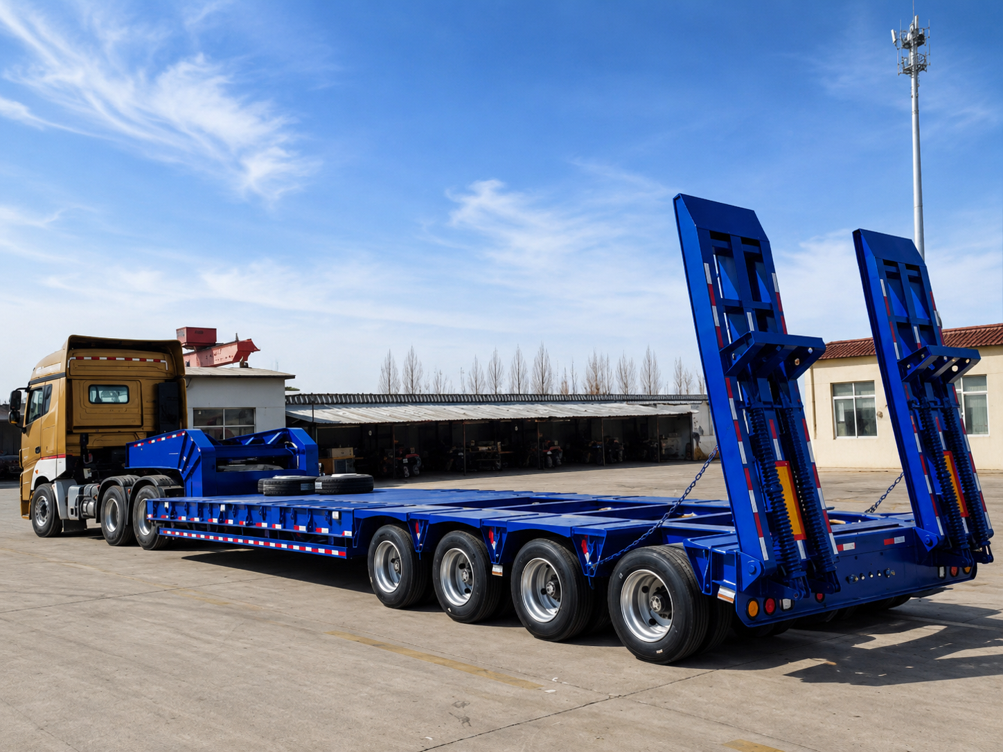 Blue lowboy trailer with multi-axle configuration and rear loading ramps